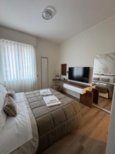 a bedroom with a large bed and a flat screen tv at B&B IV Novembre Apartment- Forum Assago - Stadio San Siro - Duomo Milano Centro - fiera Milano in Corsico