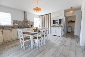 a kitchen with a table and chairs in a room at Le repere du forestier in Sabres