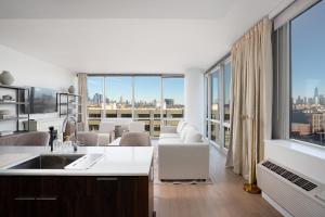 霍博肯Ultra Luxury Apt - Panoramic NYC View with Pool - Minutes to City的厨房设有带大窗户的客厅