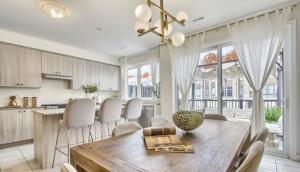 a kitchen and dining room with a wooden table and chairs at XTO Hotel in Markham