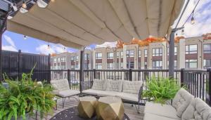a patio with white couches and tables and a building at XTO Hotel in Markham