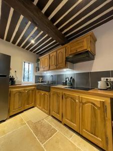 a large kitchen with wooden cabinets and a large appliance at Maison de charme in Apt +13 photos