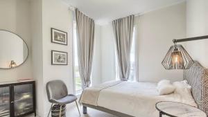 a bedroom with a bed and a chair and a window at XTO Hotel in Markham