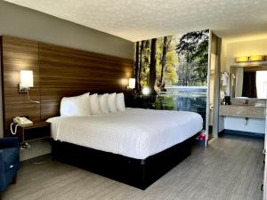 a bedroom with a large bed and a bathroom at Clarion Pointe Morrow - Atlanta South in Morrow +10 photos