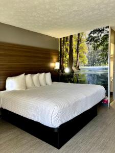 a bedroom with a large bed with a large window at Clarion Pointe Morrow - Atlanta South in Morrow