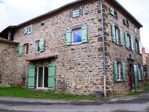 an old stone building with green doors and windows at Maison Les Sauvages Blassac 8-10 personnes in Blassac