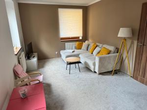 ein Wohnzimmer mit Sofa und Tisch in der Unterkunft Apartmán Železná Ruda in Železná Ruda