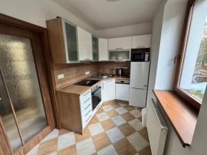 eine kleine Küche mit weißen Geräten und einem Fenster in der Unterkunft Apartmán Železná Ruda in Železná Ruda + 6 Fotos