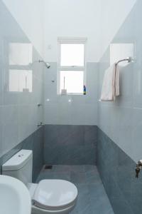 a white bathroom with a toilet and a window at Green Retreat 2 Bedroom Hideout in Polgasowita