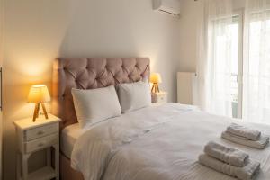 a bedroom with a large white bed with towels on it at Santa Marina 6 in Ioannina