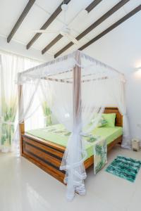 a bedroom with a bed with a canopy at Green Retreat 2 Bedroom Hideout in Polgasowita