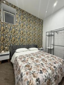 a bedroom with a bed with a floral wallpaper at Casa del puente in Ercolano