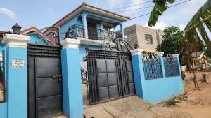 a blue house with black doors and a gate at Nuria luxurious one bed room apartment in Sekondi-Takoradi