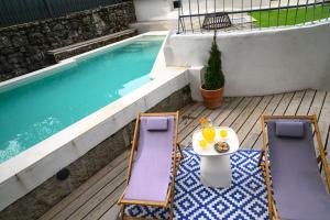 a table and two chairs next to a swimming pool at antiguo gallinero in Collado-Villalba