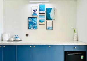 a kitchen with blue cabinets and pictures on the wall at Flamingo Hải Tiến - Sỏi Apartment in Gò Ba Quần