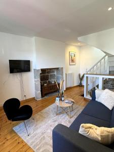a living room with a blue couch and a fireplace at Maison de charme Locmaria in Quimper