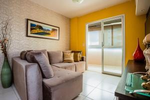 a living room with a couch and a table at Apt incrível para sua família! Com churrasqueira in Cuiabá +24 photos