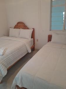 a bedroom with two beds and a window at Casa muy cerca de plaza central in San Cristóbal de Las Casas