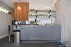 a kitchen with gray cabinets and a counter top at The Hideout-Boutique Cabin, Estuary View & Parking in Salcombe
