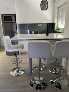 a kitchen with white chairs and a kitchen island at Villa Sandra Promajna in Promajna