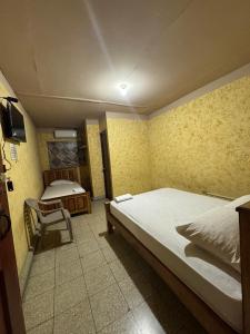 a bedroom with a bed and a chair in it at Panamá Hostels Inn in David