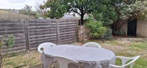 einen Tisch und Stühle in einem Hinterhof mit einem Zaun in der Unterkunft Appart'Jardin in Saint-Pierre-des-Corps