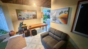 a living room with a couch and a television at Pousada EcoVillage - Meu Xodó em Preá in Prea
