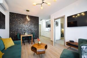 a living room with a couch and a table at Apartament POD SŁOŃCEM BAŁTYKU w Perle Mórz-Ustronie Morskie Sianożęty in Sianozety