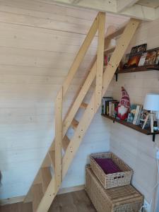 a wooden staircase in a room with a wall at tiny house Cantal in Marcolès