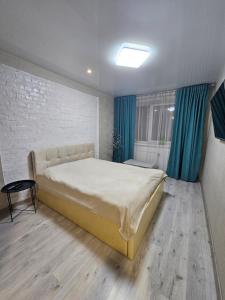 a bedroom with a large bed and blue curtains at ЖК Яровиця in Lutsk