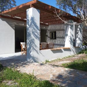 a white house with a wooden roof at Cottage2 ησυχαστήριο,άνετο,οικολογικο in Sissi