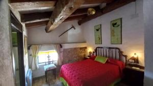 a bedroom with a red bed and a window at Mirador de las Tejadas in Alobras