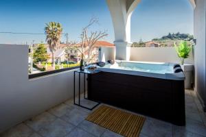 a bath tub in a room with a window at Mamfredas Suites in Kypseli