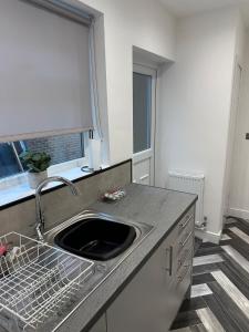 a kitchen with a sink and a window at Cosy 2-bed flat, great location in South Shields +7 photos