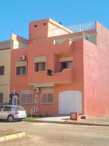 ein rosafarbenes Gebäude mit einem davor geparkt in der Unterkunft Maison d'hôte Najah 1 in Khenifra + 18 Fotos