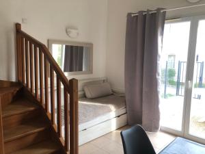 a room with a bed and a staircase with a window at Maison dans une residence fermée in Mouriès +5 photos