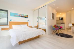 sypialnia z dużym białym łóżkiem i biurkiem w obiekcie Eshkol Housing Haifa - Wallenberg Suites Complex w mieście Hajfa