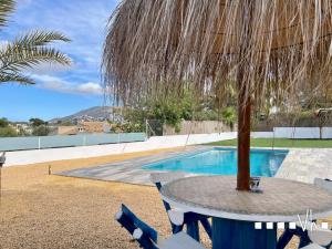 a table with a palm tree next to a swimming pool at VH CostaBlanca - LA COMETA in Teulada +61 photos