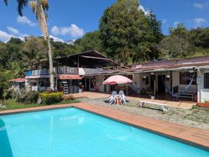 a swimming pool in front of a house at Finca Las Hamacas- La Posada del pensamiento in Santa Beatríz