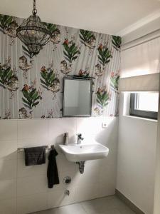 a bathroom with a sink and a mirror at Apartment im Grünen mit Stil in Mitterfels +16 photos