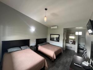 a hotel room with two beds and a television at Hotel Luna Park in Tijuana