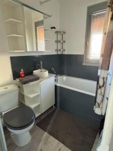 ein Badezimmer mit Toilette, Waschbecken und Badewanne in der Unterkunft Petit cottage à 3 minutes à pied de la plage avec terrasse et Parking privée gratuit in Blonville-sur-Mer