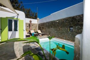 dom z basenem obok kamiennej ściany w obiekcie Casa Annaise Mykonos - Cycladic Gem with Pool & Jacuzzi w mieście Mykonos