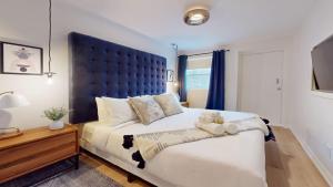 a bedroom with a large bed with a teddy bear on it at Casa East Side Hotel Queen East Leslieville Suite in Toronto