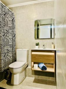 a bathroom with a toilet and a sink and a mirror at Laguna verde in Los Ángeles