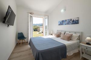 um quarto com uma cama, uma TV e uma janela em Villa Daniela- Costa Rei a 5 minuti a piedi dalla spiaggia con AC, WiFi e Parcheggi Privati em Costa Rei