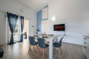 uma sala de jantar com uma mesa branca e cadeiras azuis em Villa Daniela- Costa Rei a 5 minuti a piedi dalla spiaggia con AC, WiFi e Parcheggi Privati em Costa Rei
