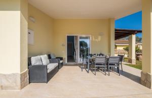 um pátio com um sofá, uma mesa e cadeiras em Villa Daniela- Costa Rei a 5 minuti a piedi dalla spiaggia con AC, WiFi e Parcheggi Privati em Costa Rei