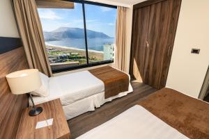 een hotelkamer met een bed en een groot raam bij Studio 56 Apart Hotel by Terrado Iquique in Iquique +89 foto's