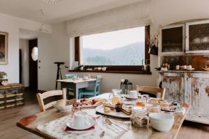 a table with plates of food on it in a room at Fra Rose e Mughi in Domegge di Cadore